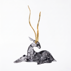 Crystal deer figurine with gold antlers on a white background